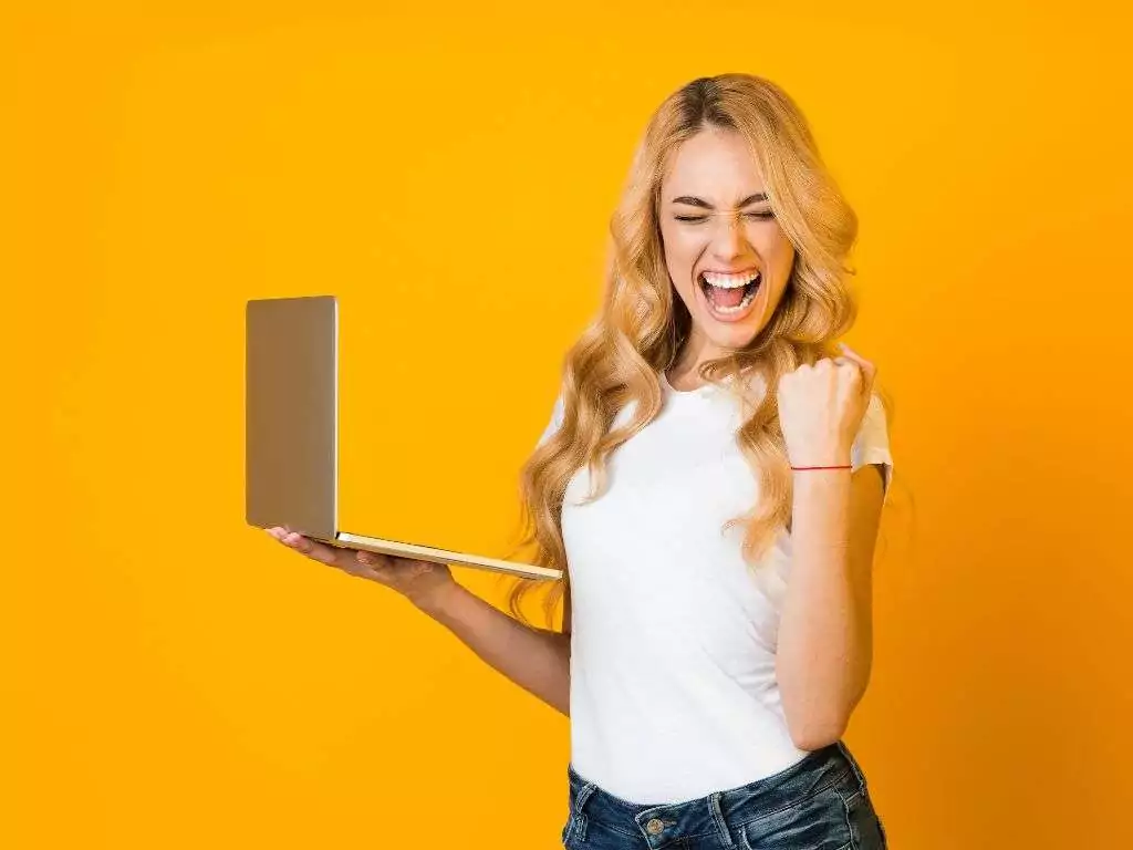 Femme heureuse avec son ordinateur car elle a améliorer la visibilité de son site internet.