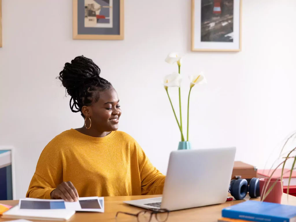 Photo d’une entrepreneure à son bureau, planifiant son contenu sur Notion, sur un ordinateur.